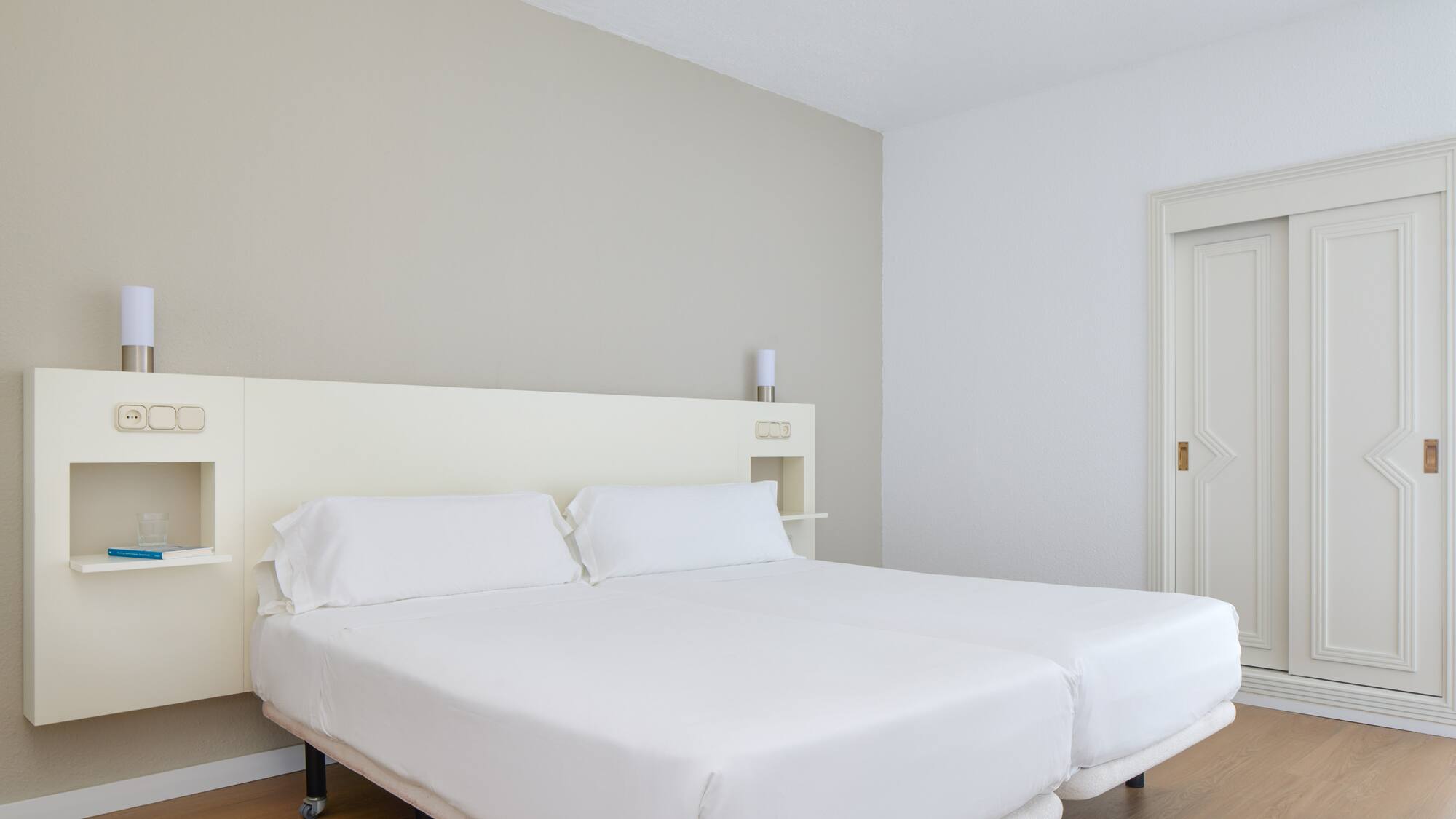 a bed with white sheets in a room