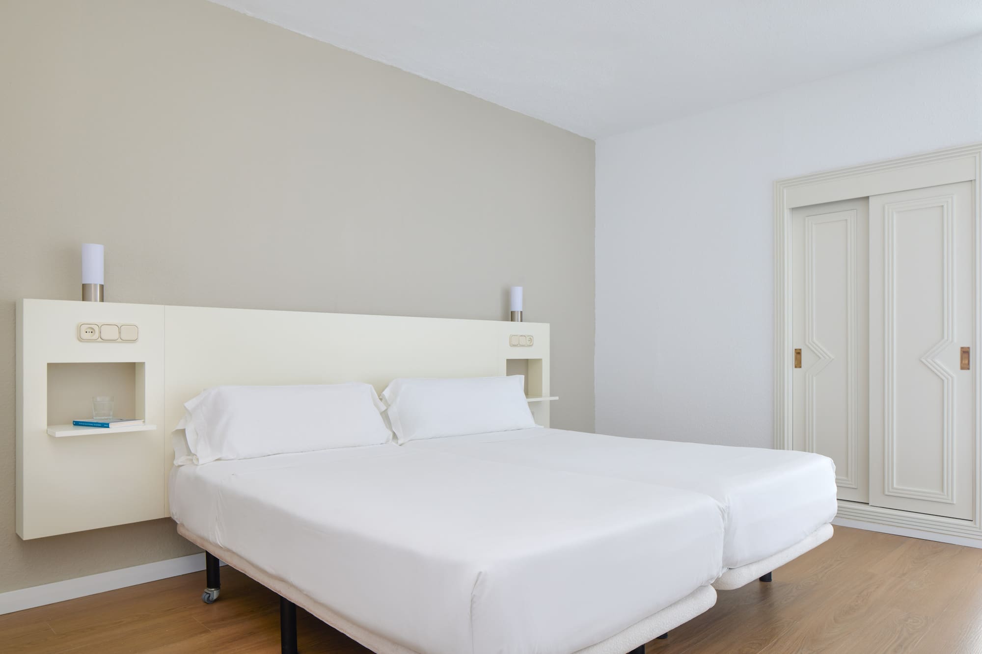 a bed with white sheets in a room