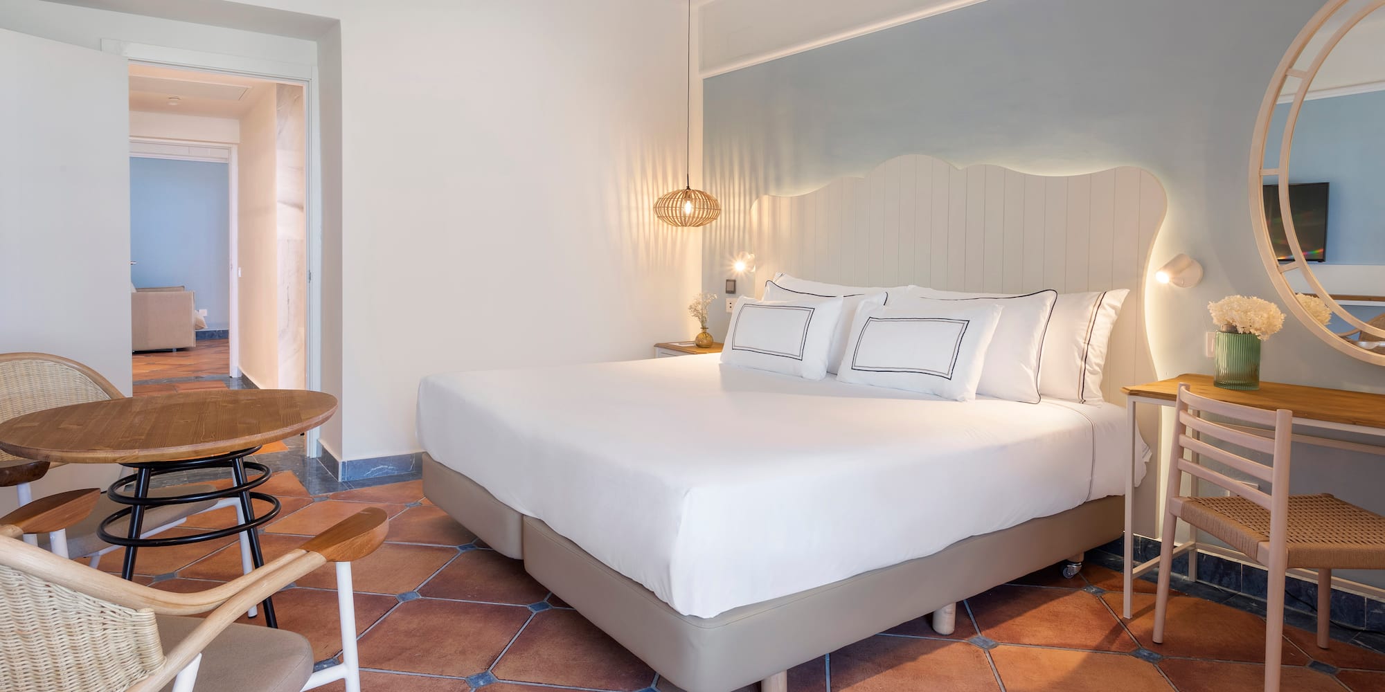 a bed with white sheets and a table in a room