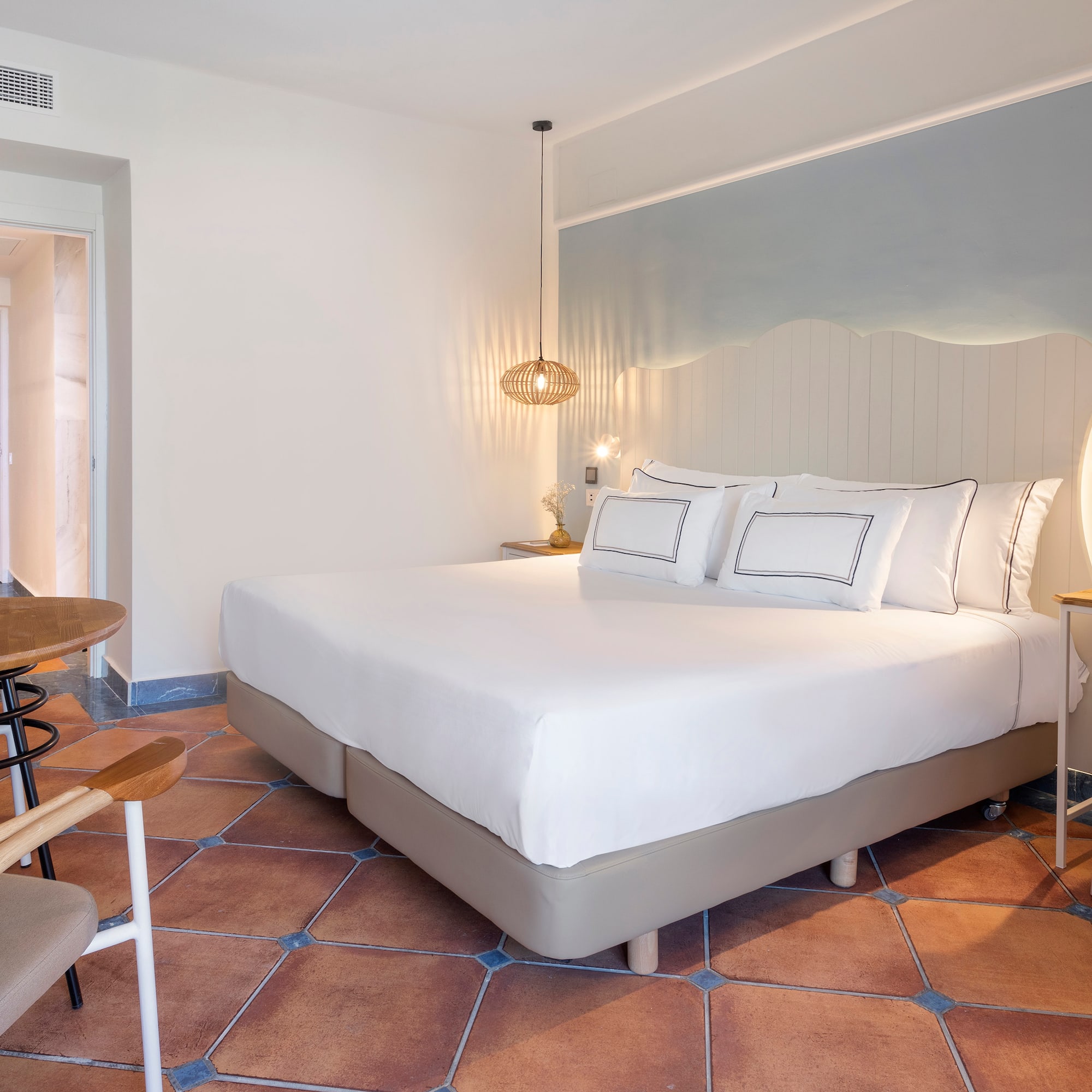 a bed with white sheets and a table in a room