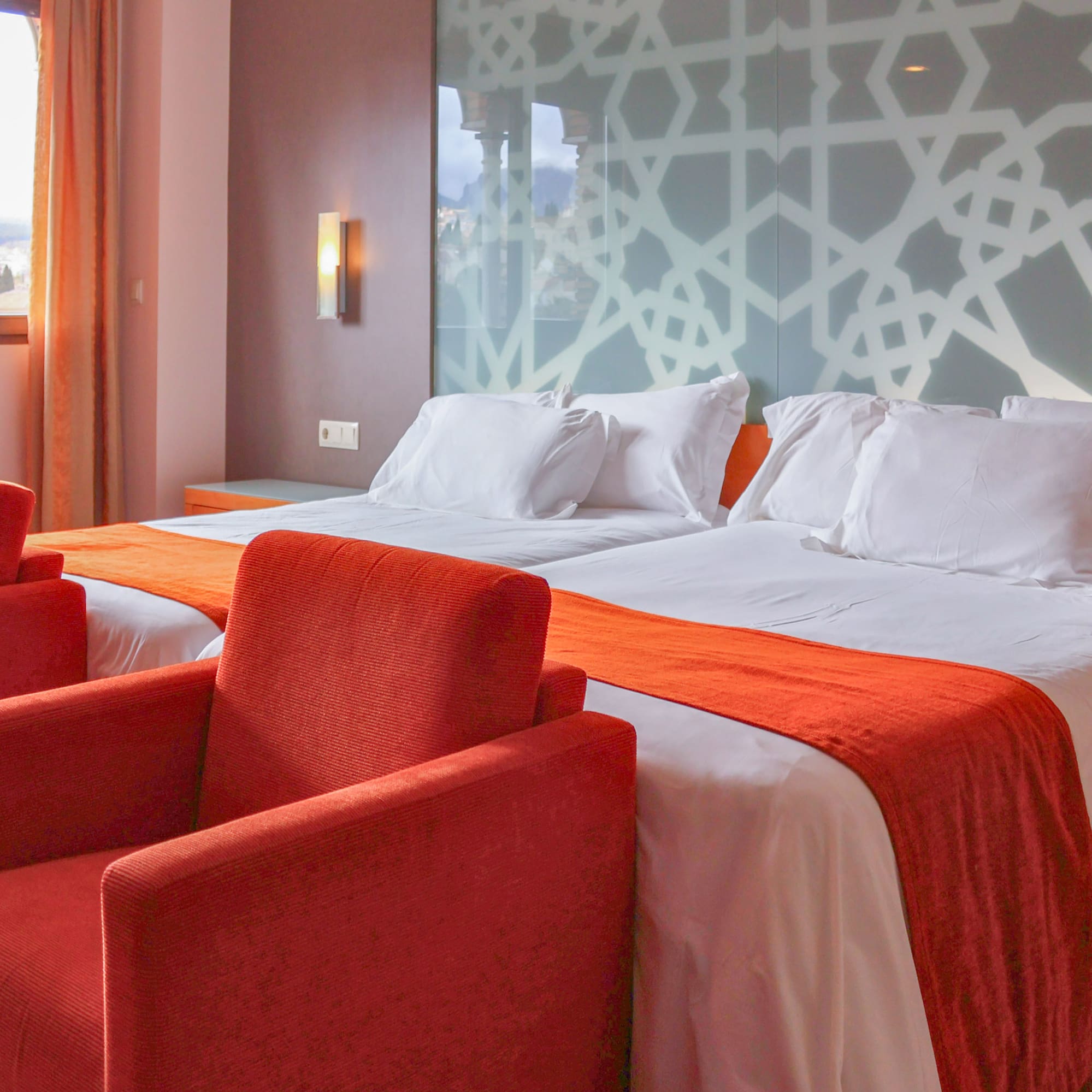 a room with two beds and red chairs