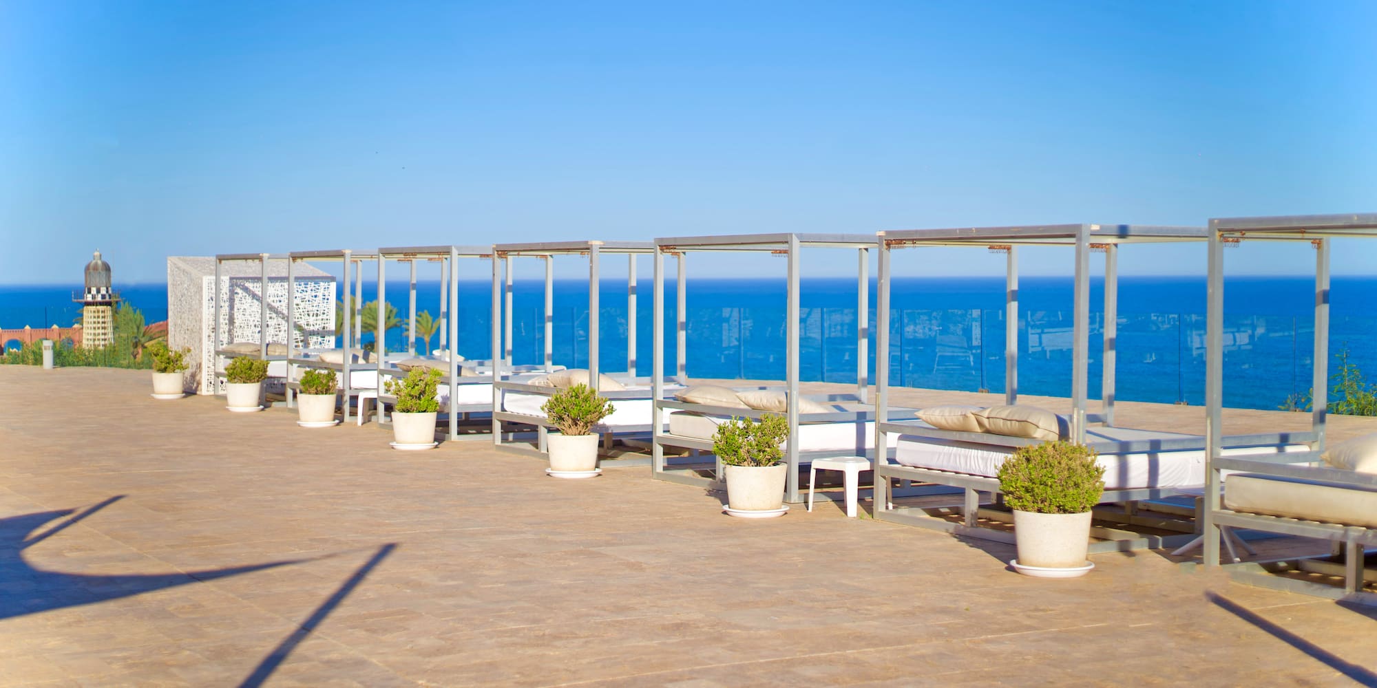 a group of beds on a patio overlooking the ocean