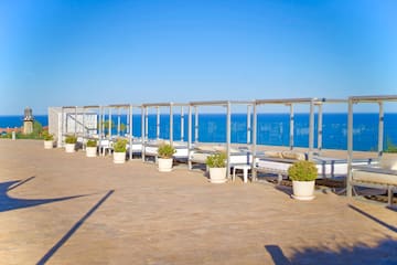 a group of beds on a patio overlooking the ocean