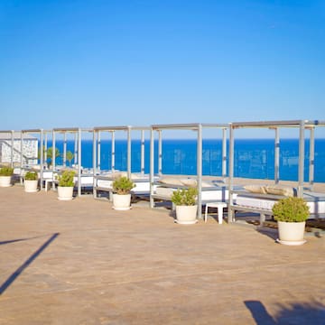 a group of beds on a patio overlooking the ocean