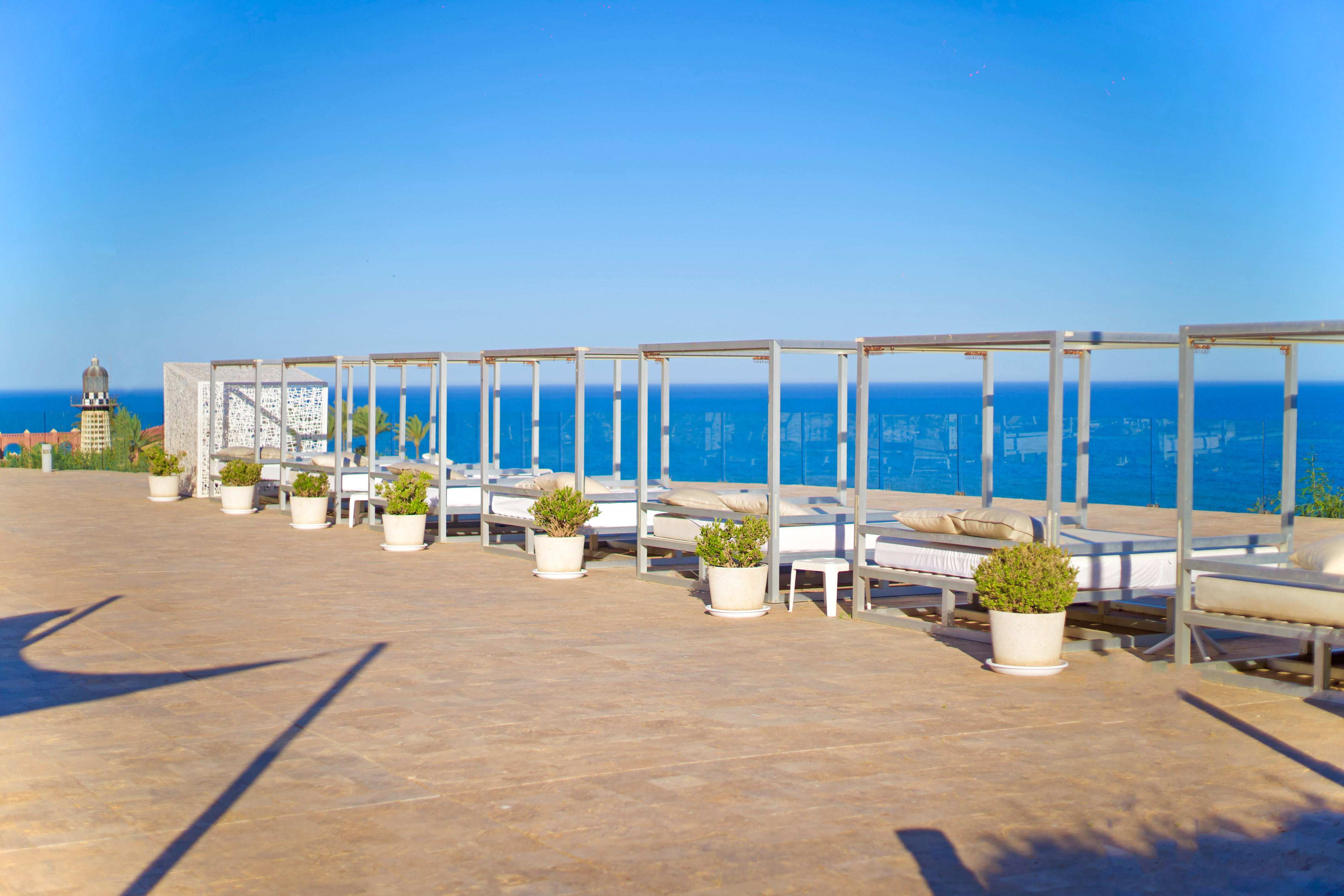 a group of beds on a patio overlooking the ocean