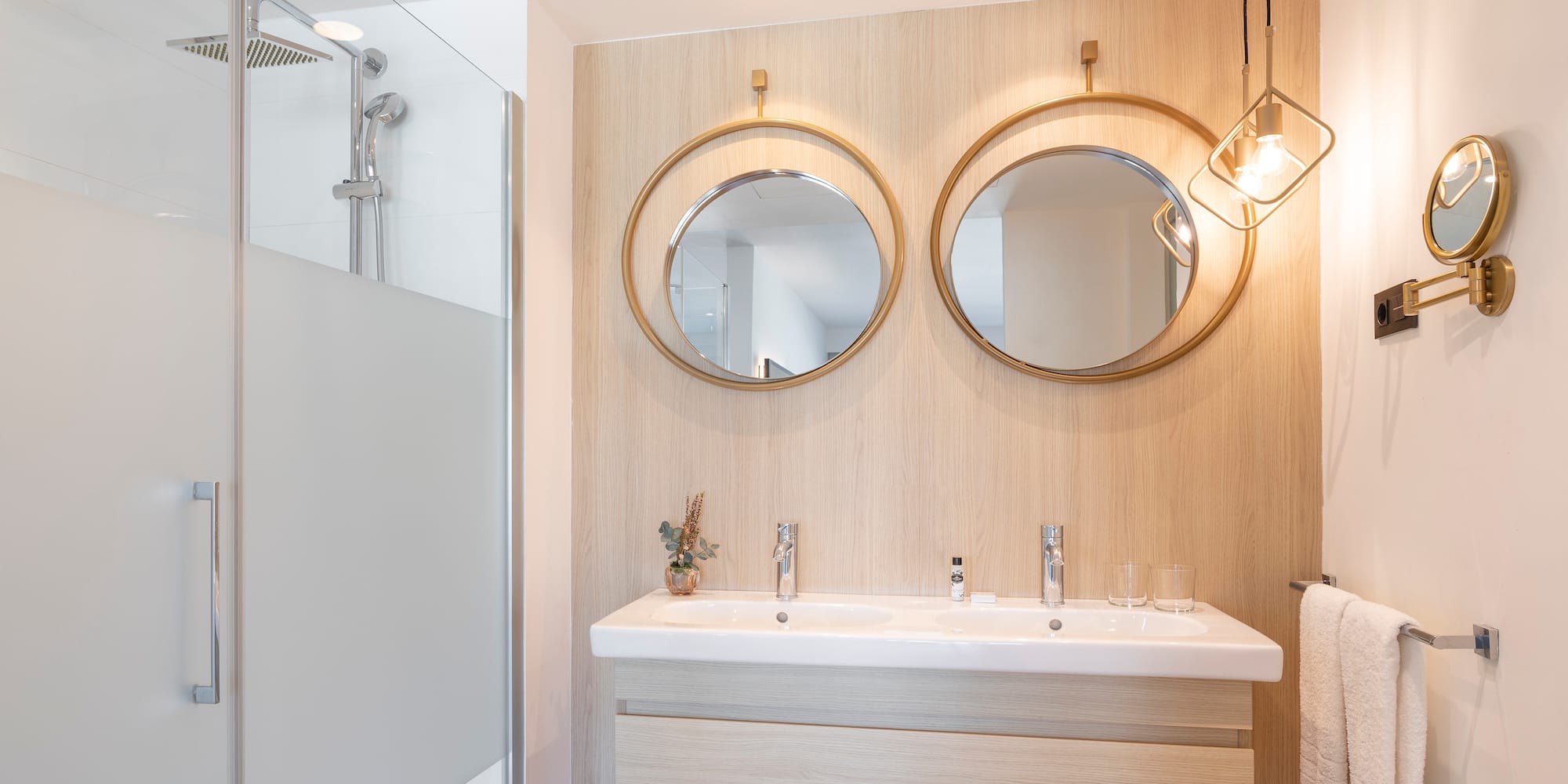 a bathroom with a shower and two mirrors