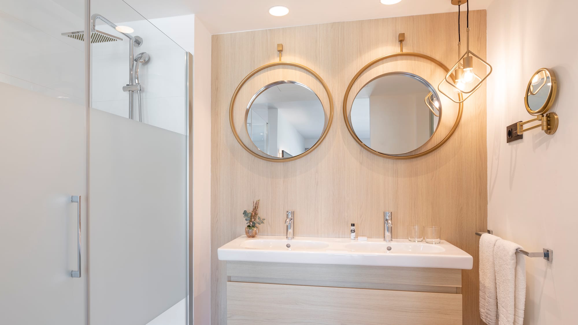 a bathroom with a shower and two mirrors
