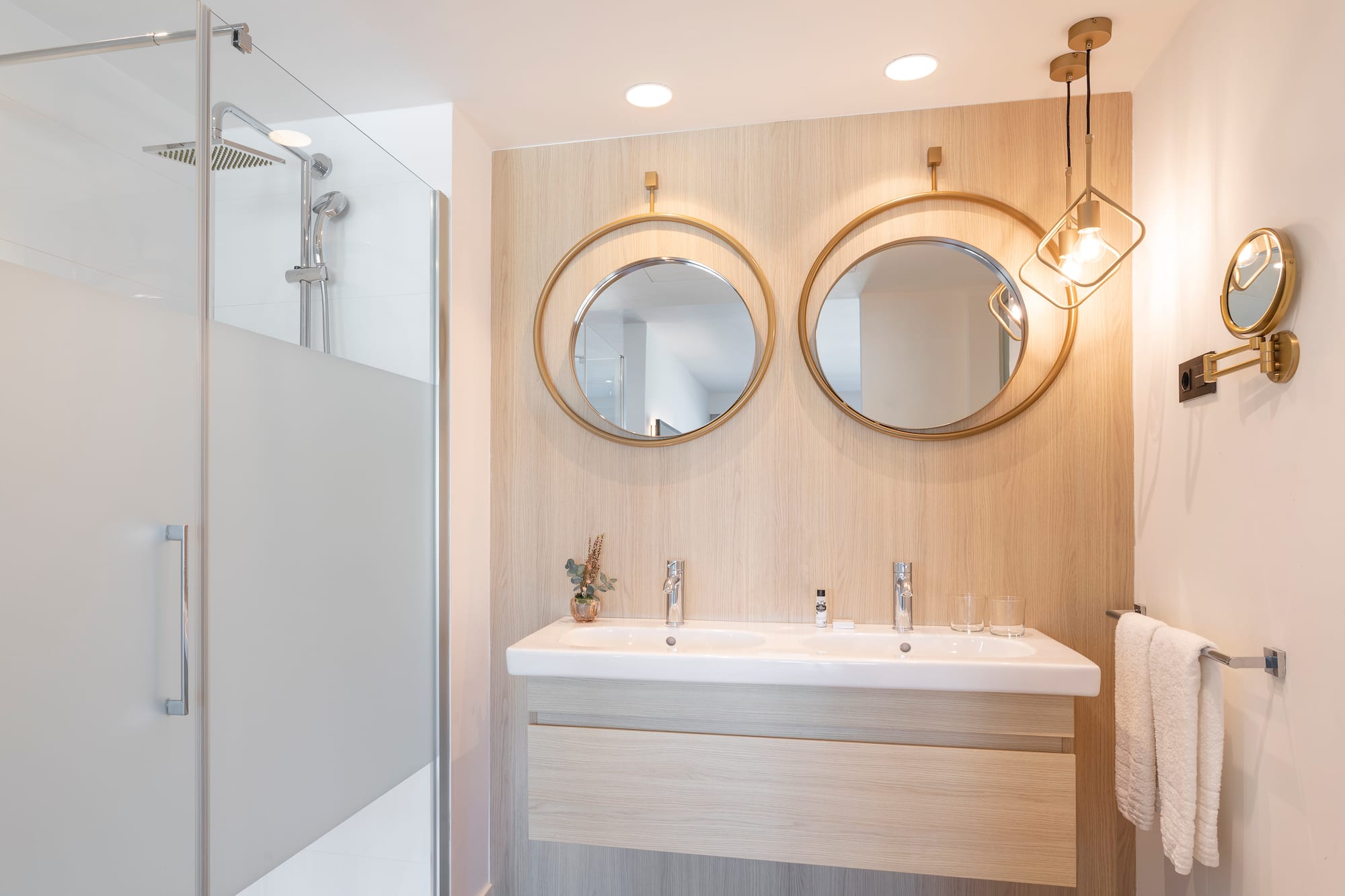 a bathroom with a shower and two mirrors