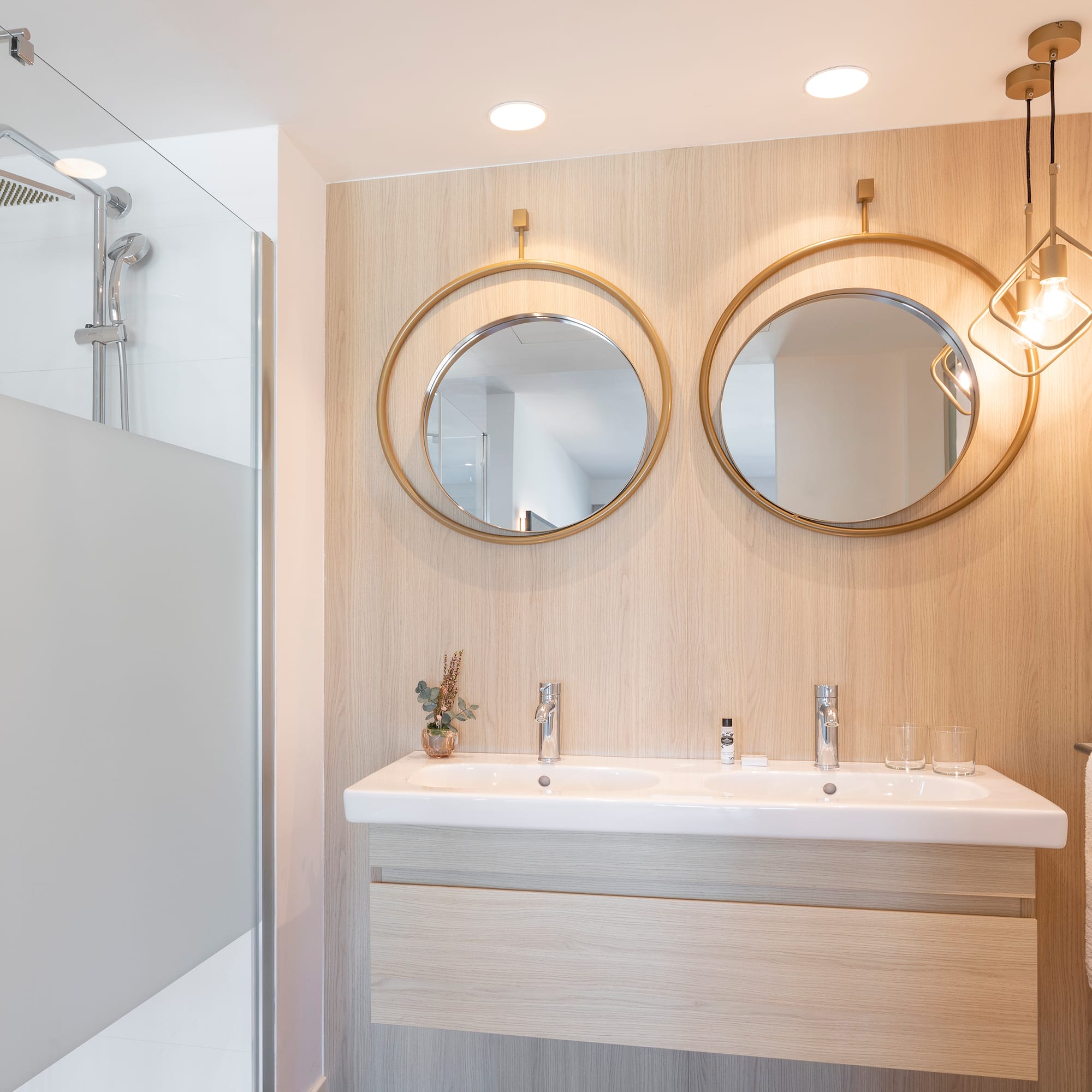 a bathroom with a shower and two mirrors
