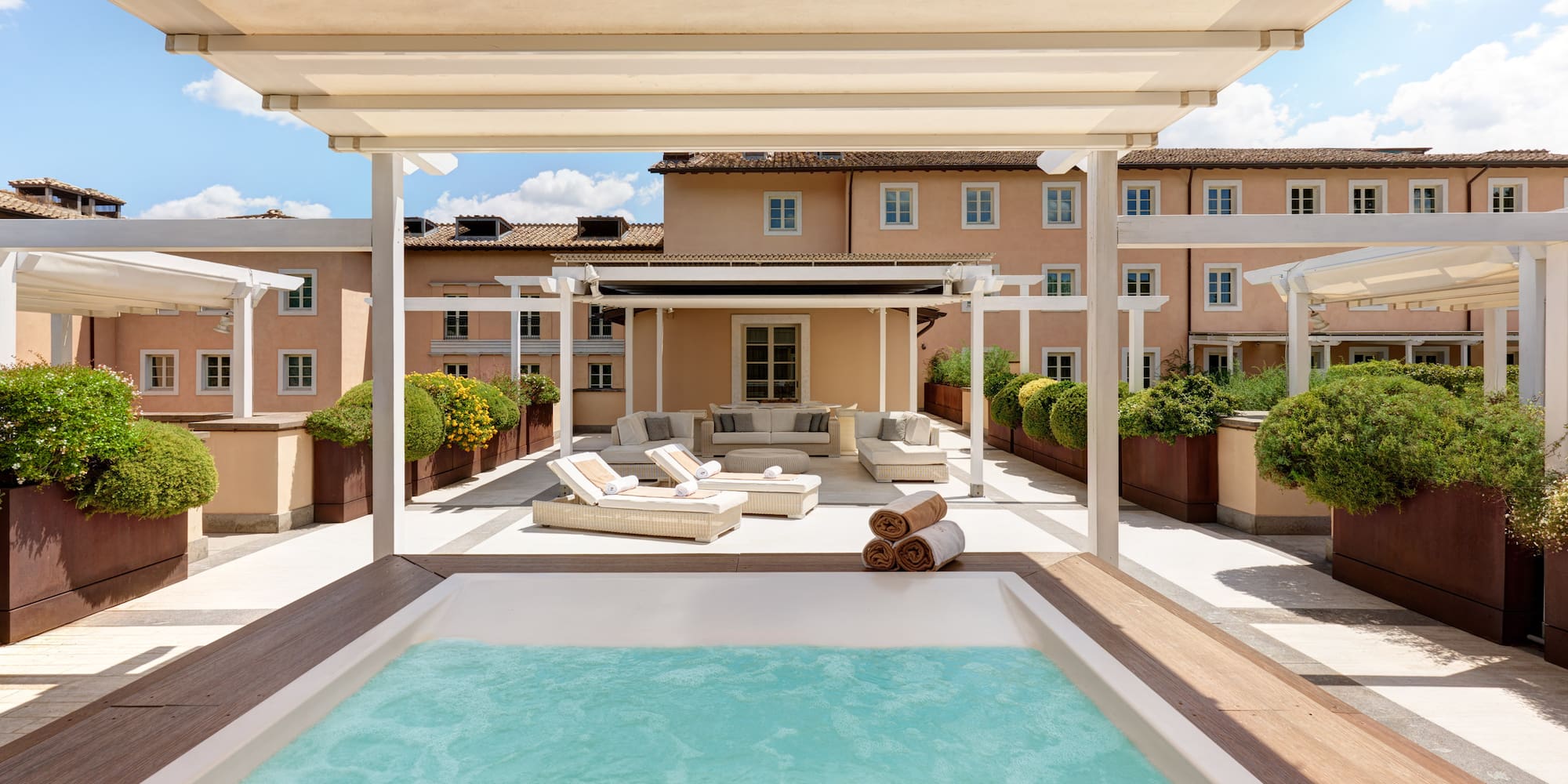 a pool with a deck and a patio with a large building