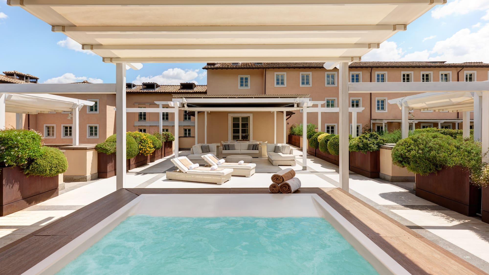 a pool with a deck and a patio with a large building
