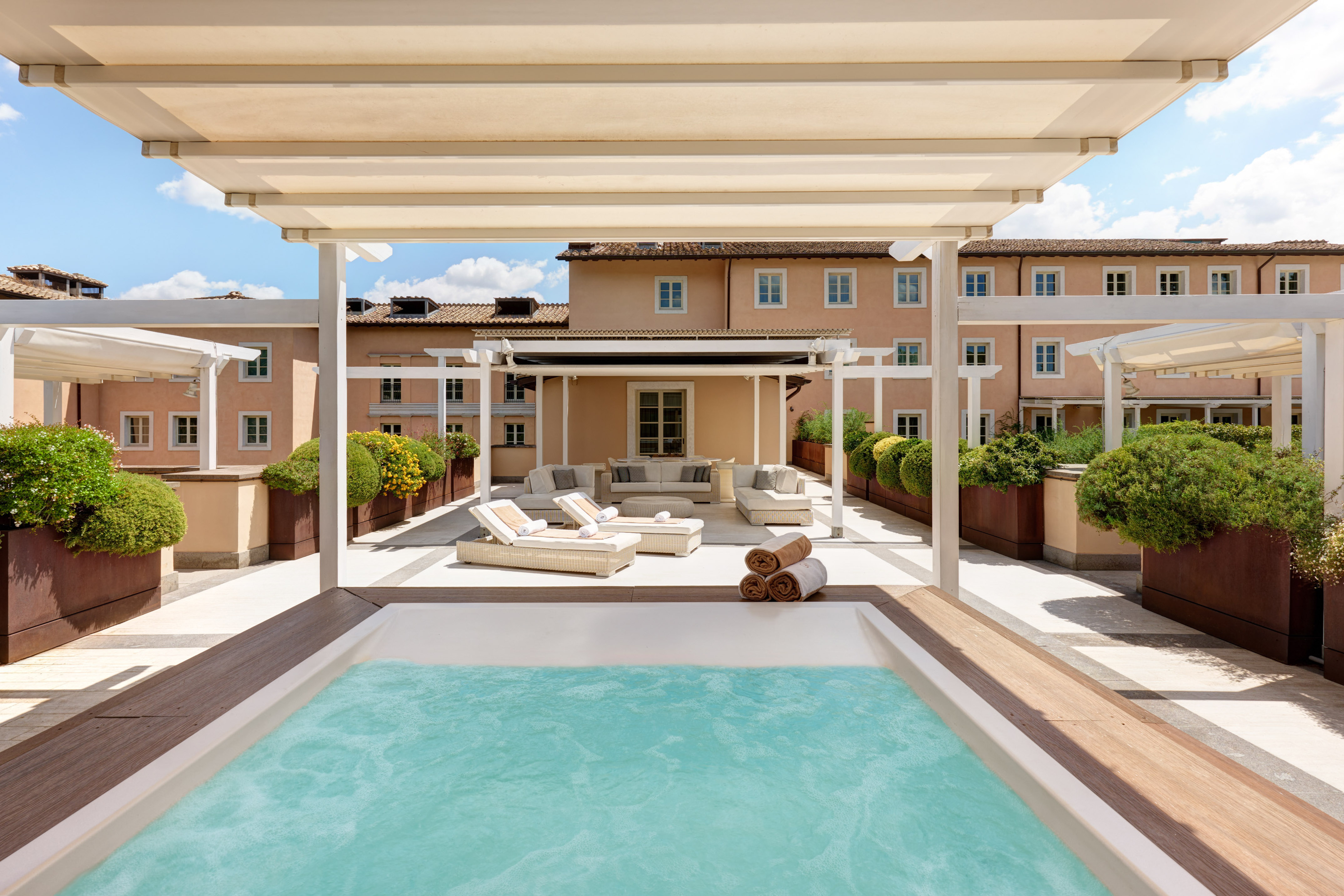 a pool with a deck and a patio with a large building