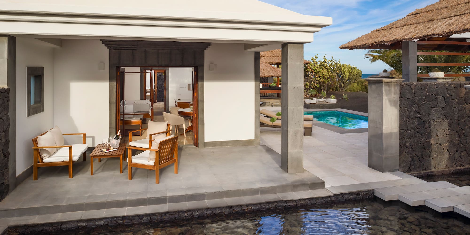 a pool and a house with chairs