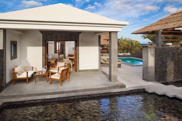 a pool and a house with chairs