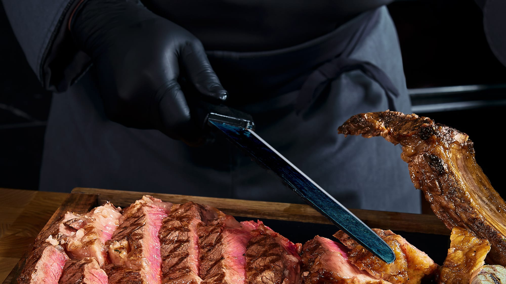 a person cutting meat on a wooden board