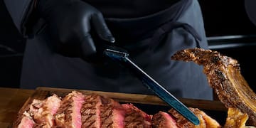 a person cutting meat on a wooden board