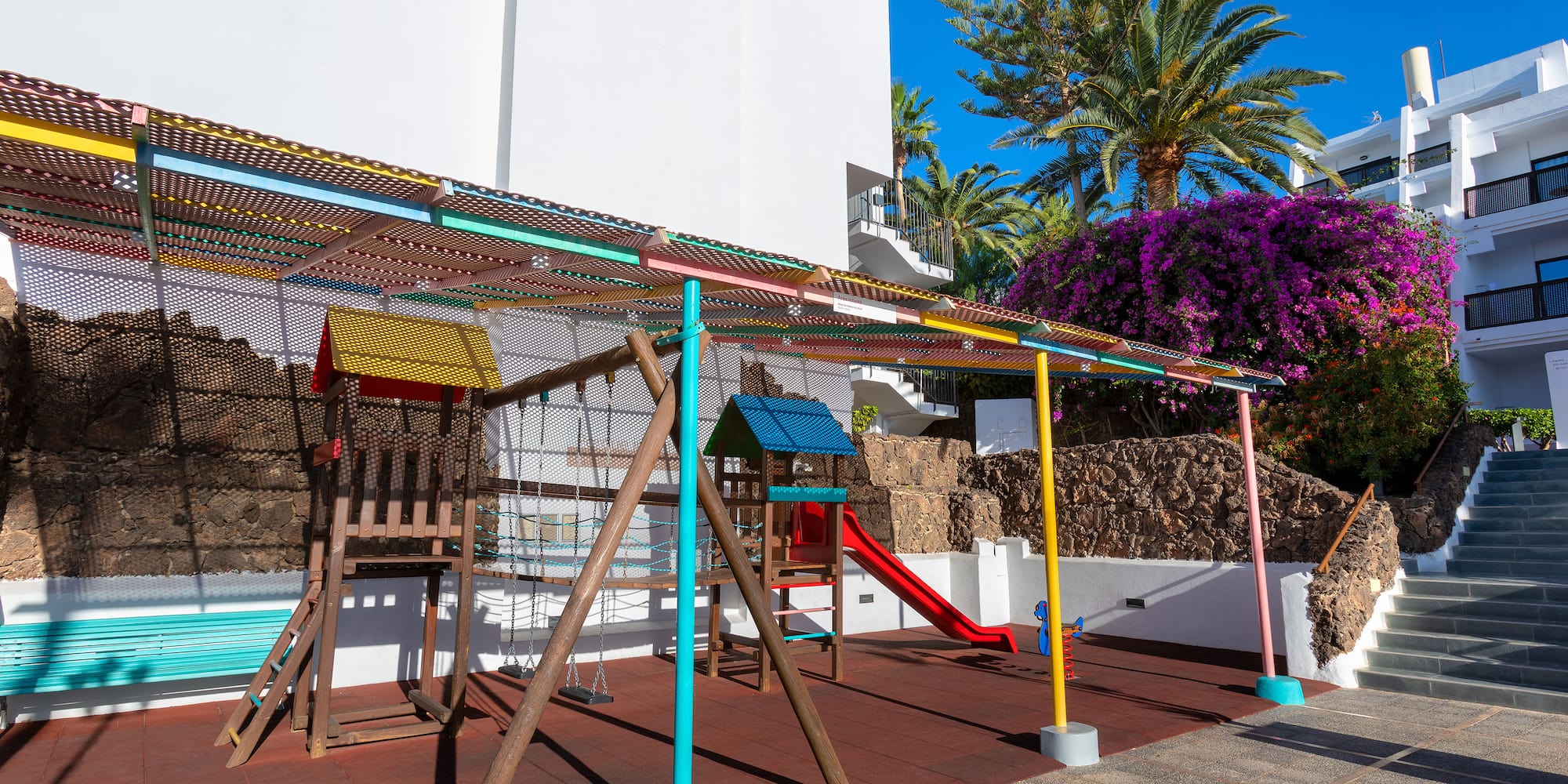 a playground with colorful poles and a slide