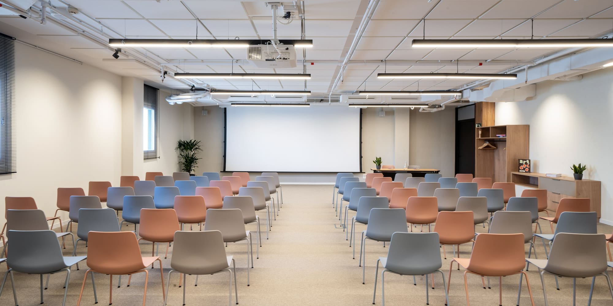 a room with many chairs and a projector screen