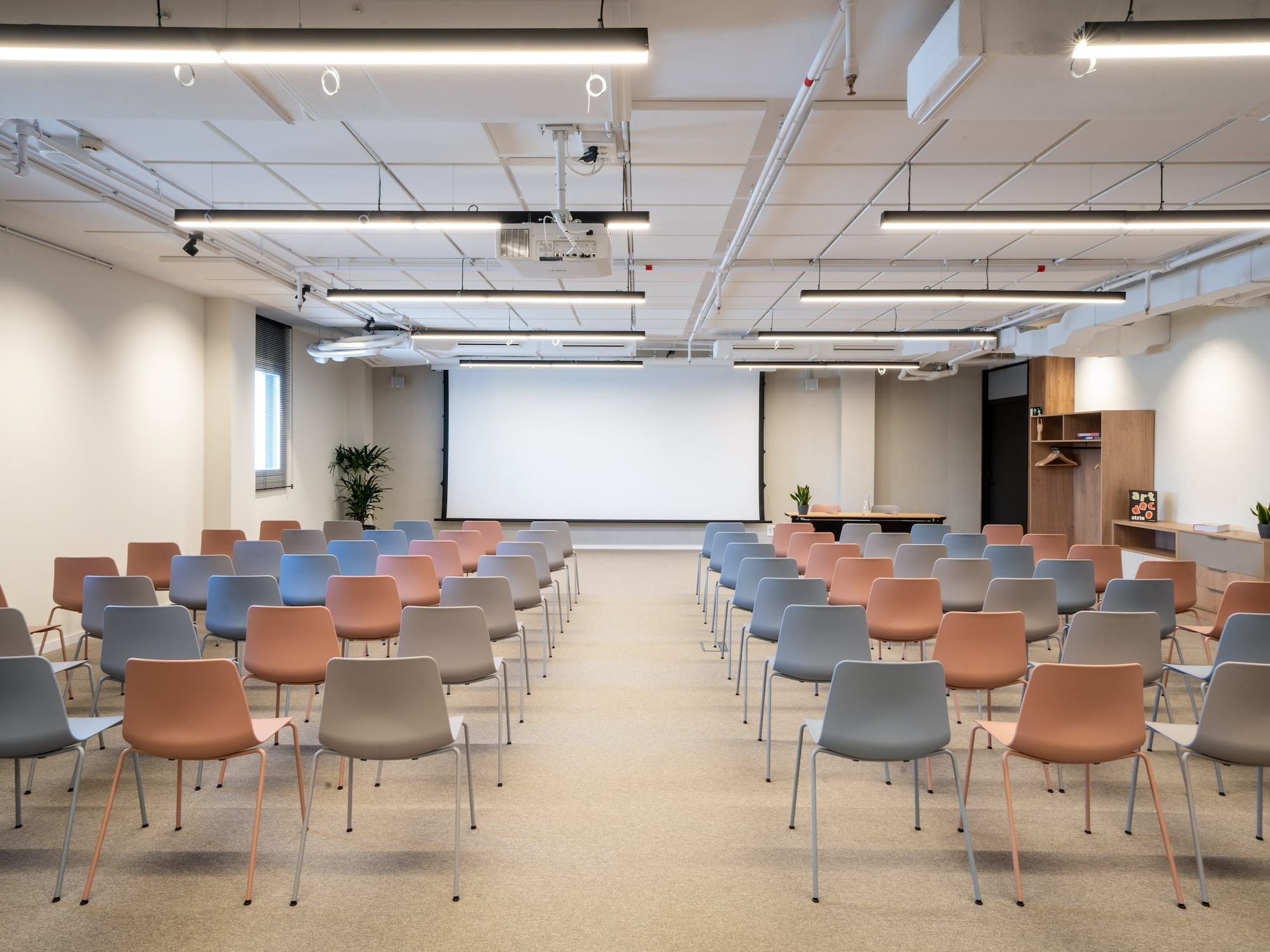 a room with many chairs and a projector screen