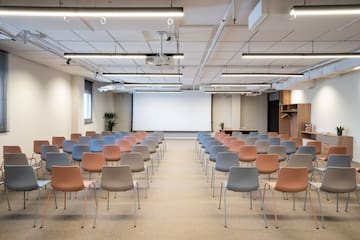 a room with many chairs and a projector screen