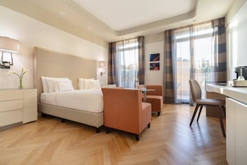 a room with a bed and chairs