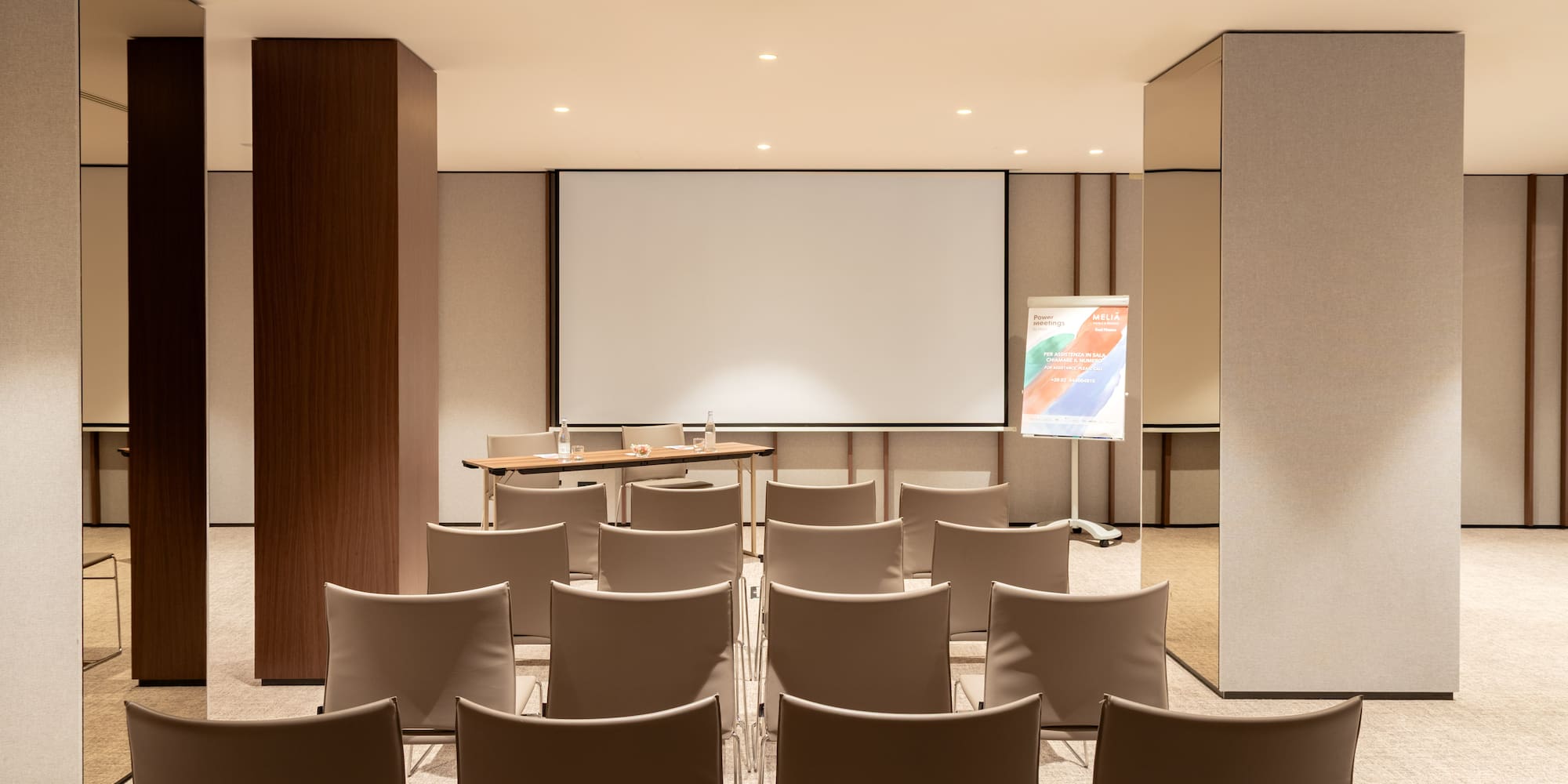 a room with chairs and a projector screen