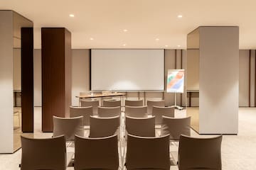 a room with chairs and a projector screen