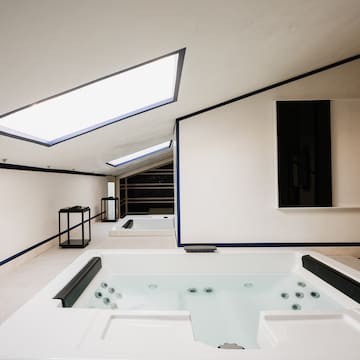 a room with a hot tub and a mirror