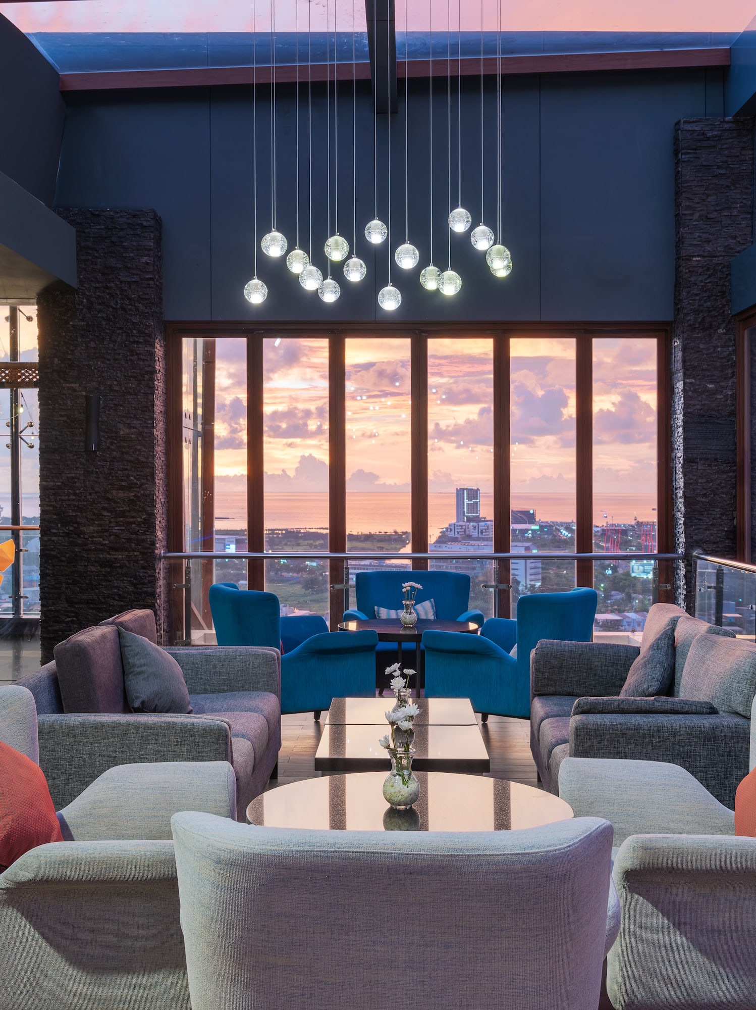 a room with a large window and a couch and chairs