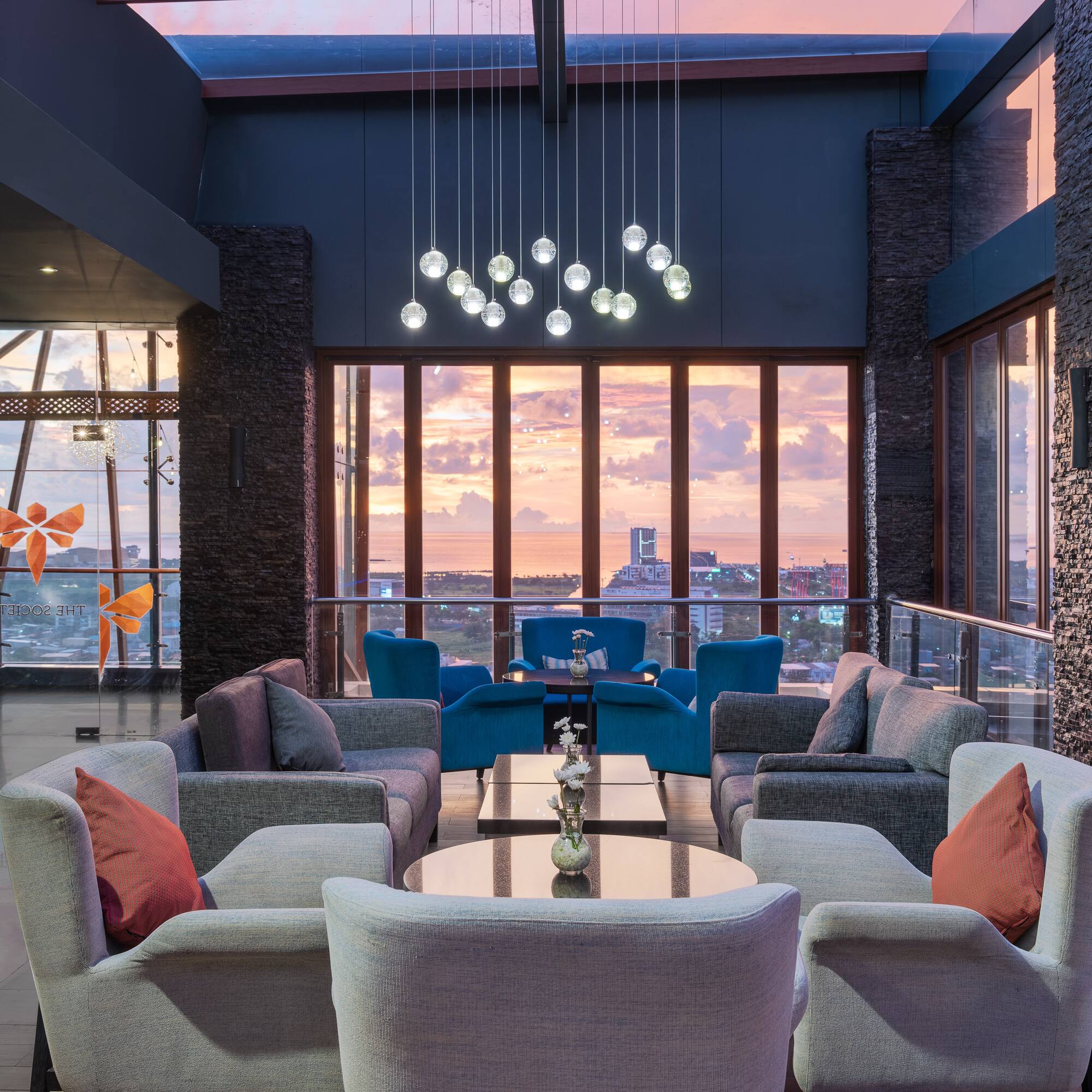 a room with a large window and a couch and chairs