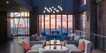 a room with a large window and a couch and chairs