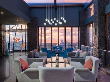 a room with a large window and a couch and chairs