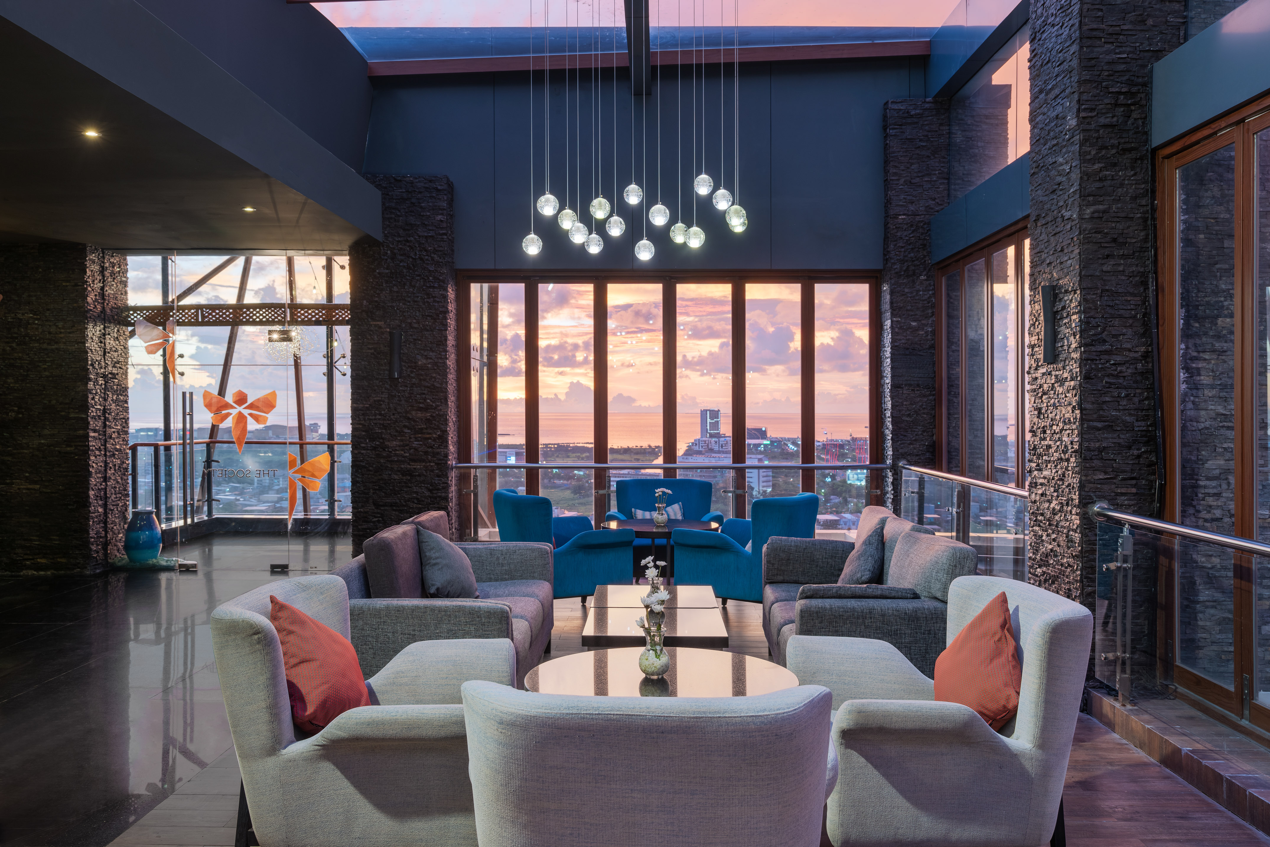 a room with a large window and a couch and chairs