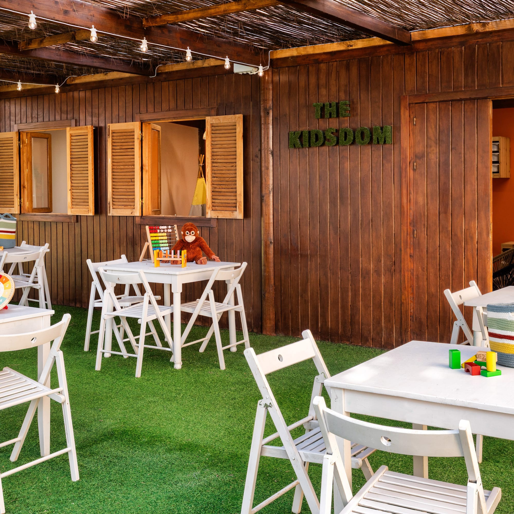 a small outdoor restaurant with white tables and chairs