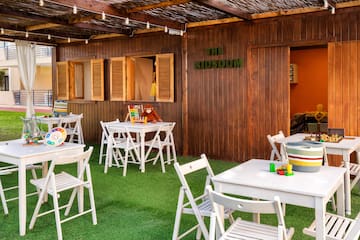 a small outdoor restaurant with white tables and chairs
