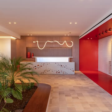 a room with a red wall and a white counter and plants
