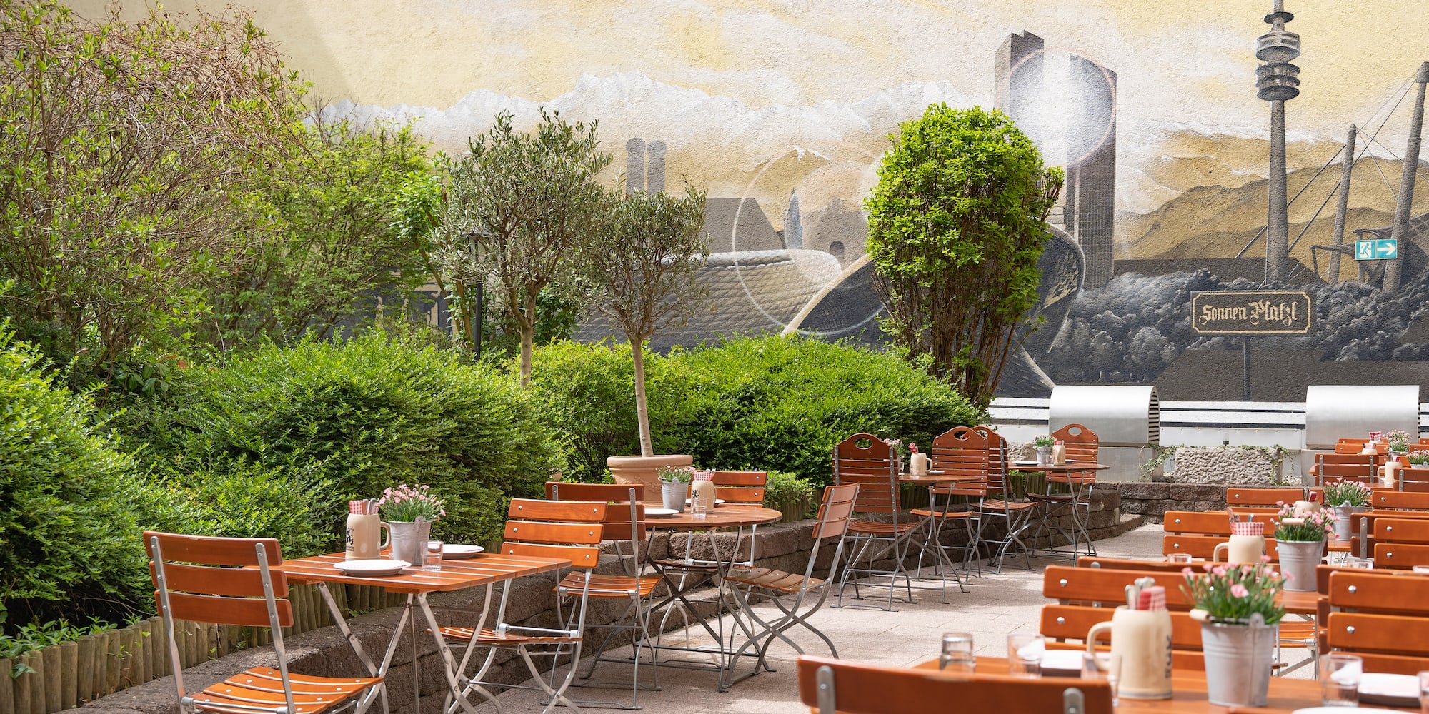 a table and chairs outside with a mural on the wall