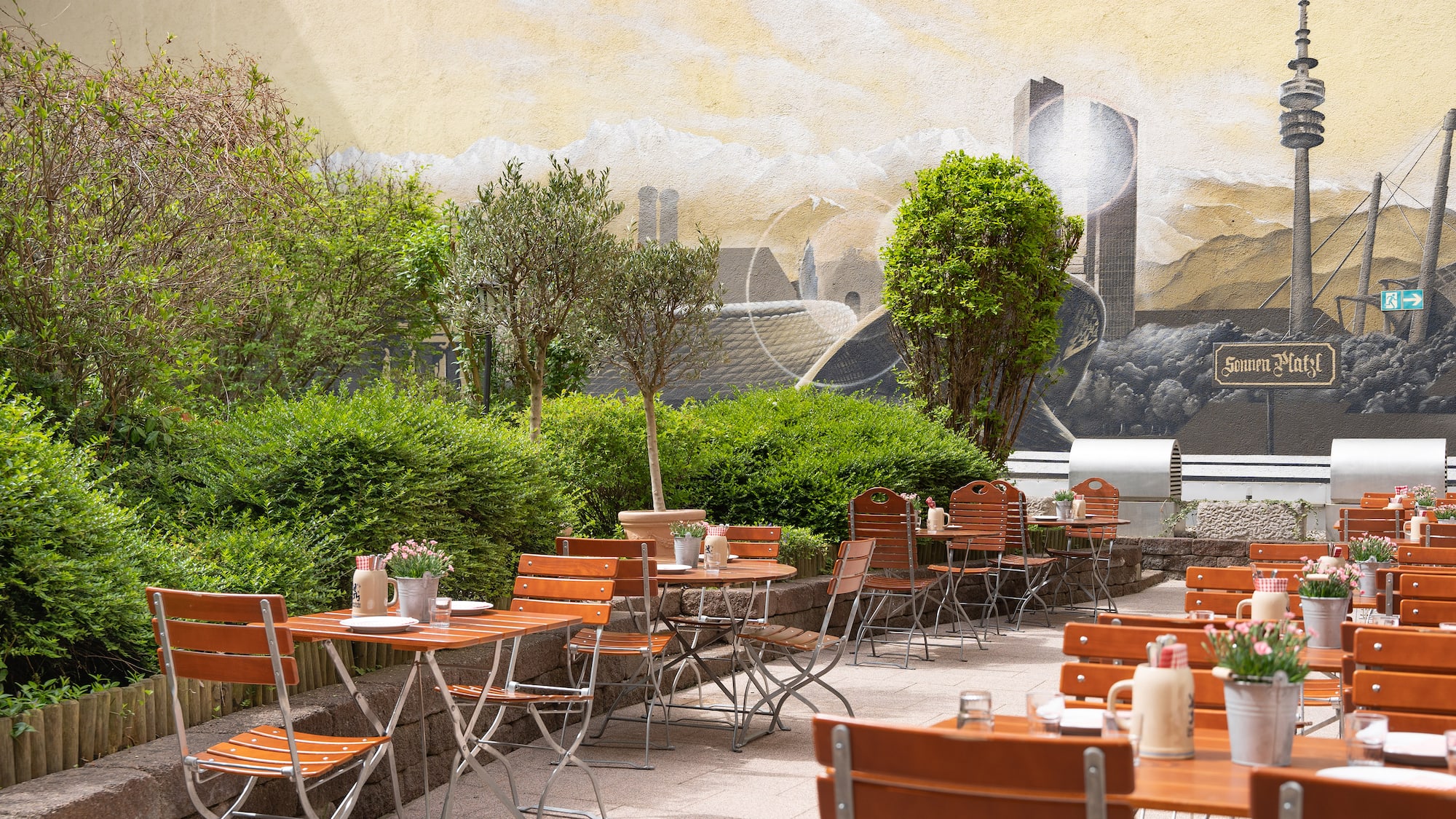 a table and chairs outside with a mural on the wall