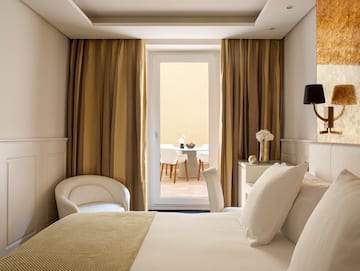 a bedroom with a bed and chairs