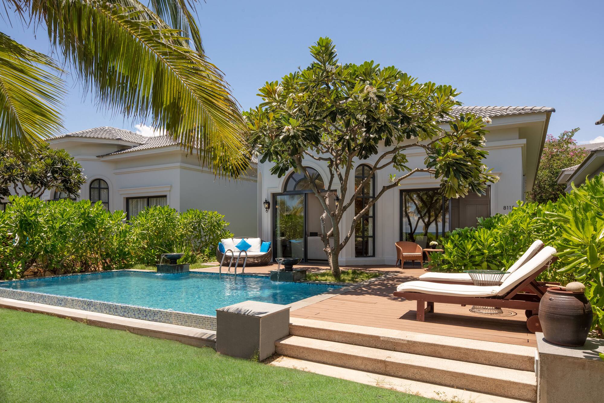 Tropical villa resort with private pool, sun loungers, and lush garden.