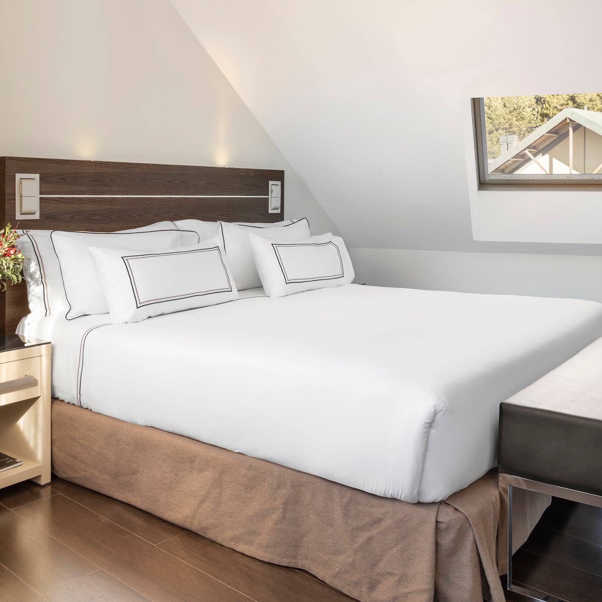 a bed with white sheets and a brown bedding