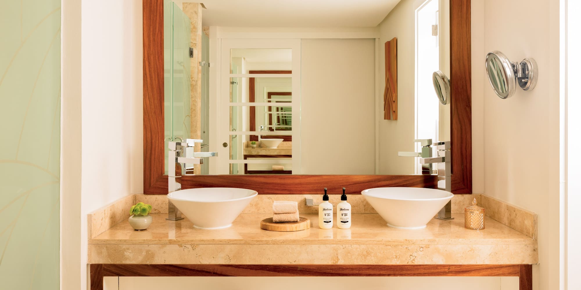 Modern double sink bathroom vanity with marble counter and wood-framed mirror.