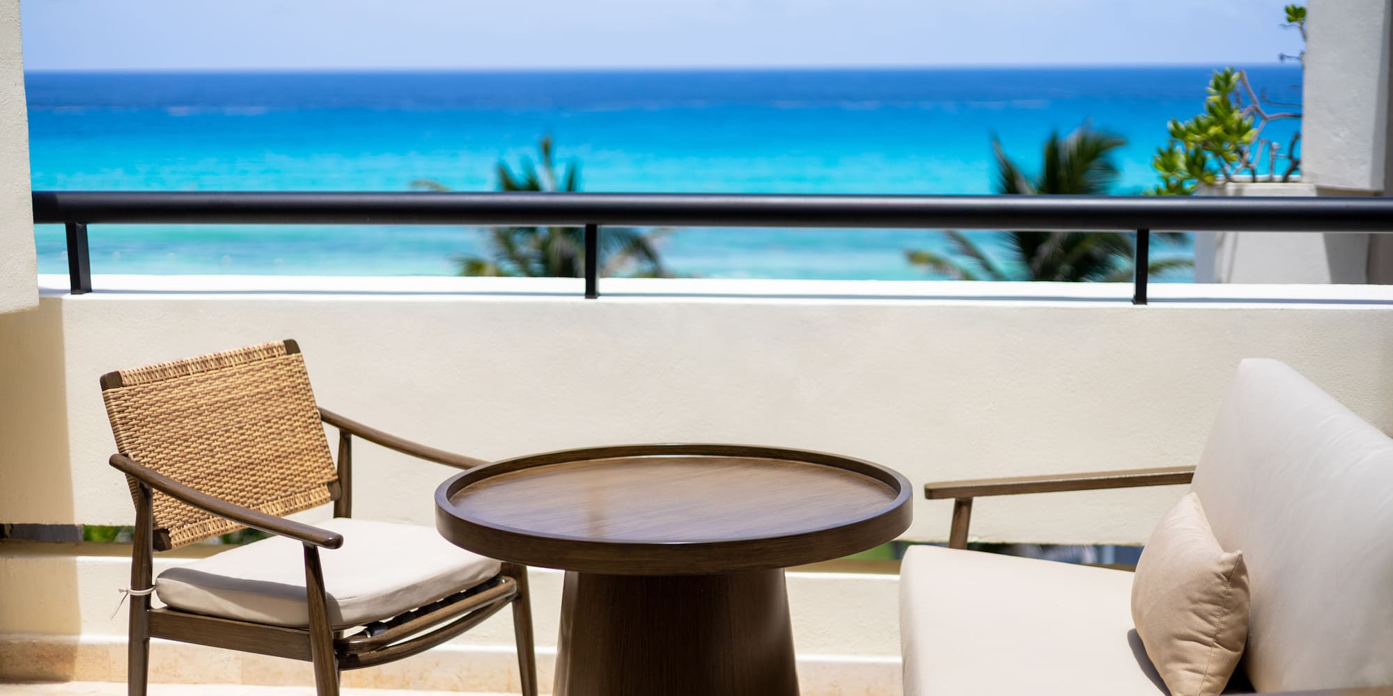 a table and chairs on a balcony overlooking the ocean
