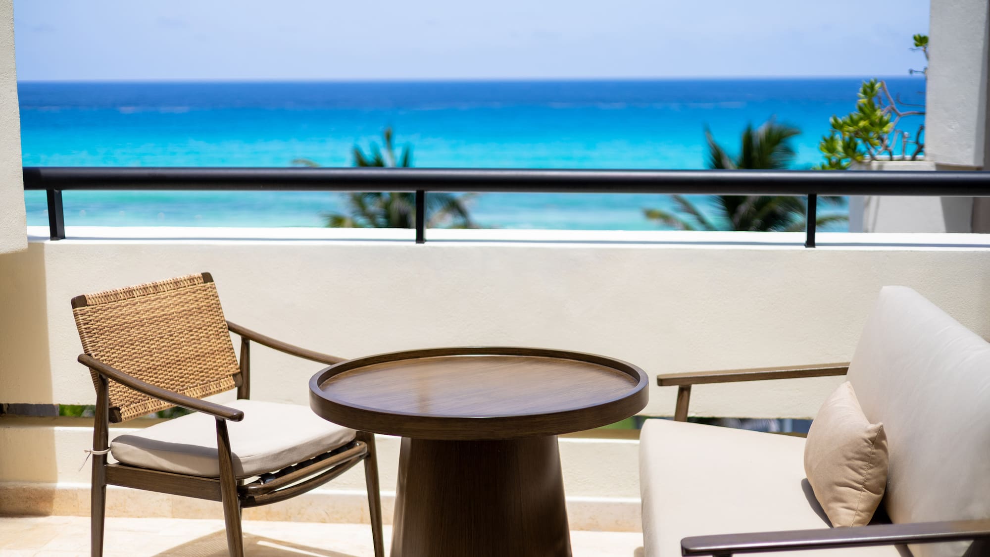 a table and chairs on a balcony overlooking the ocean