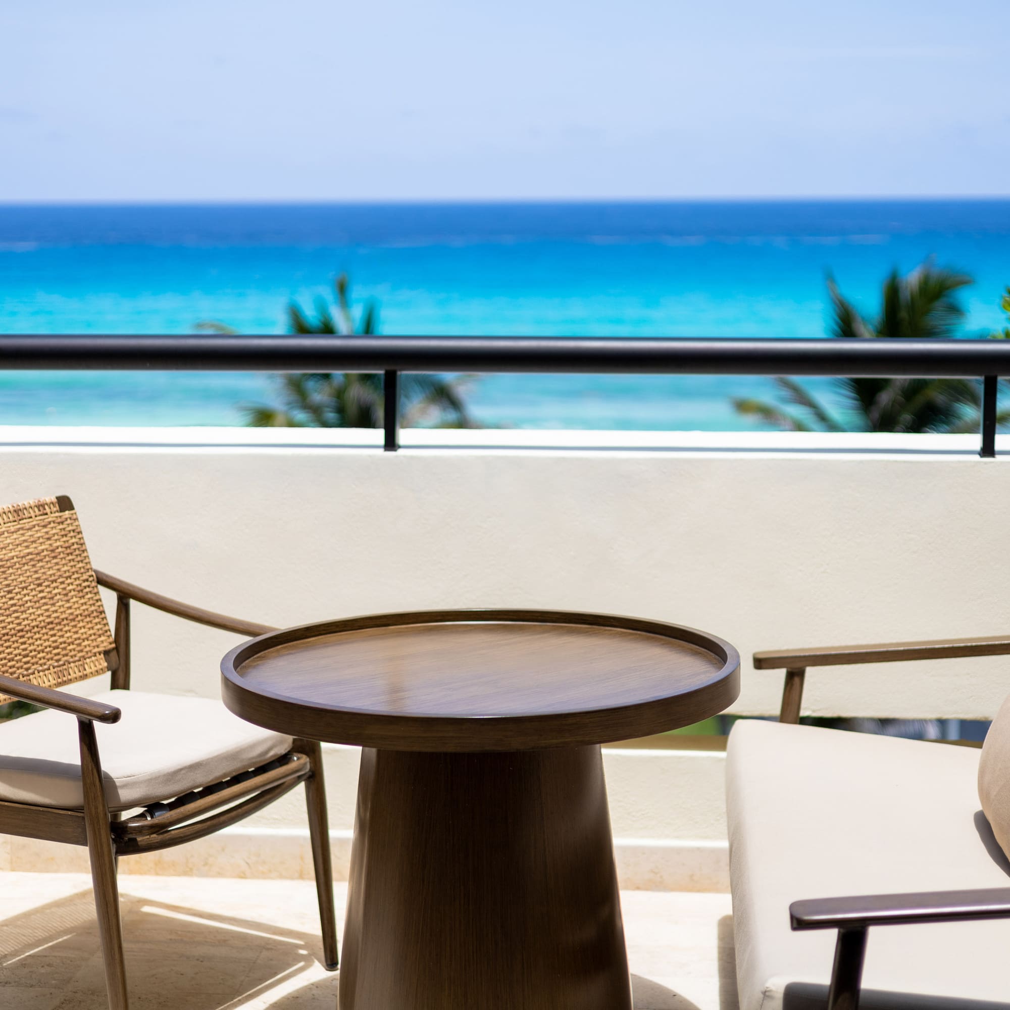 a table and chairs on a balcony overlooking the ocean