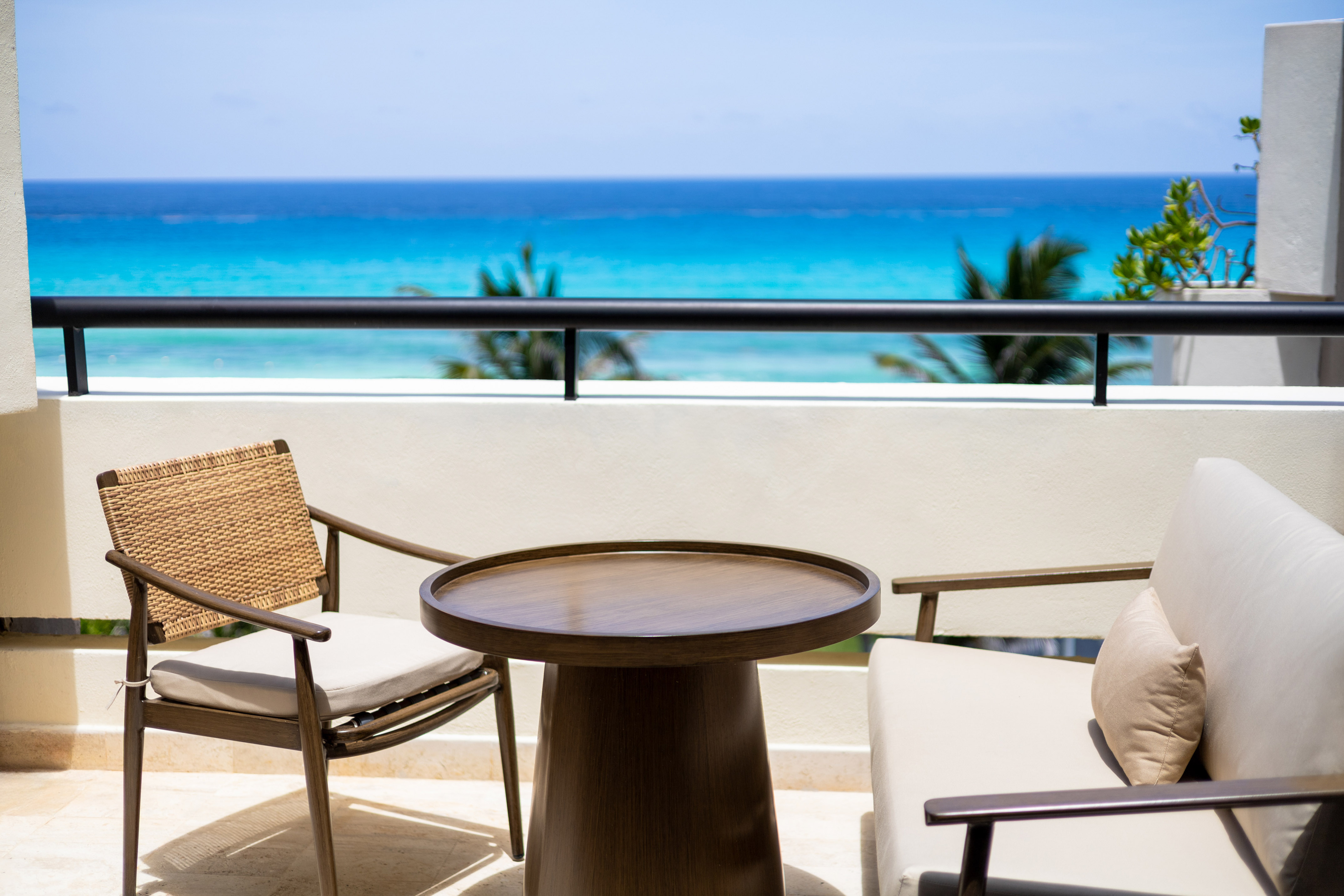 a table and chairs on a balcony overlooking the ocean