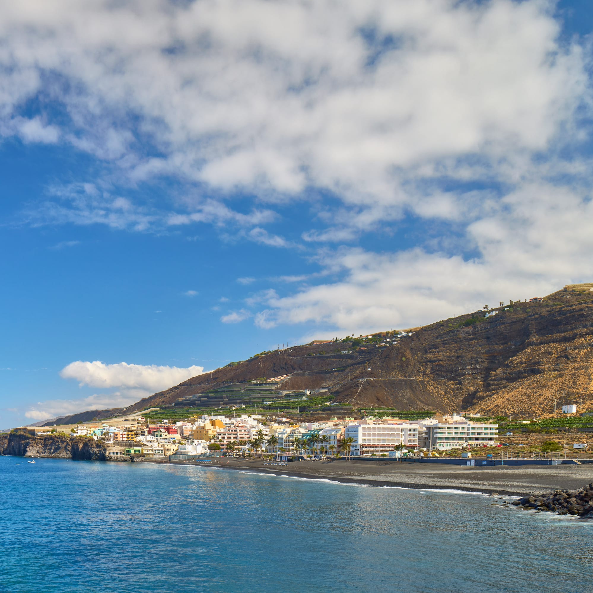 a beach with buildings and a body of water