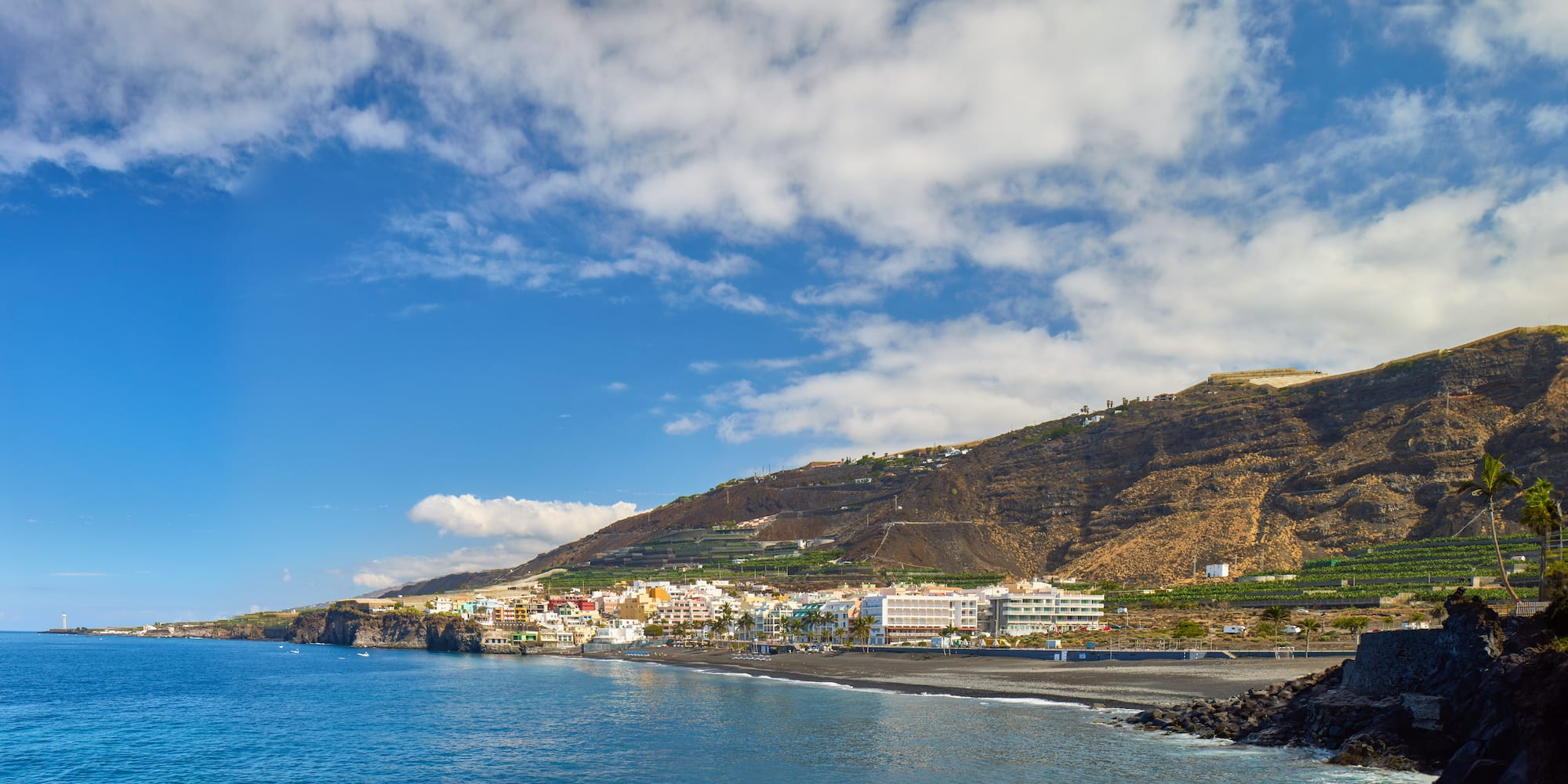 a beach with buildings and a body of water