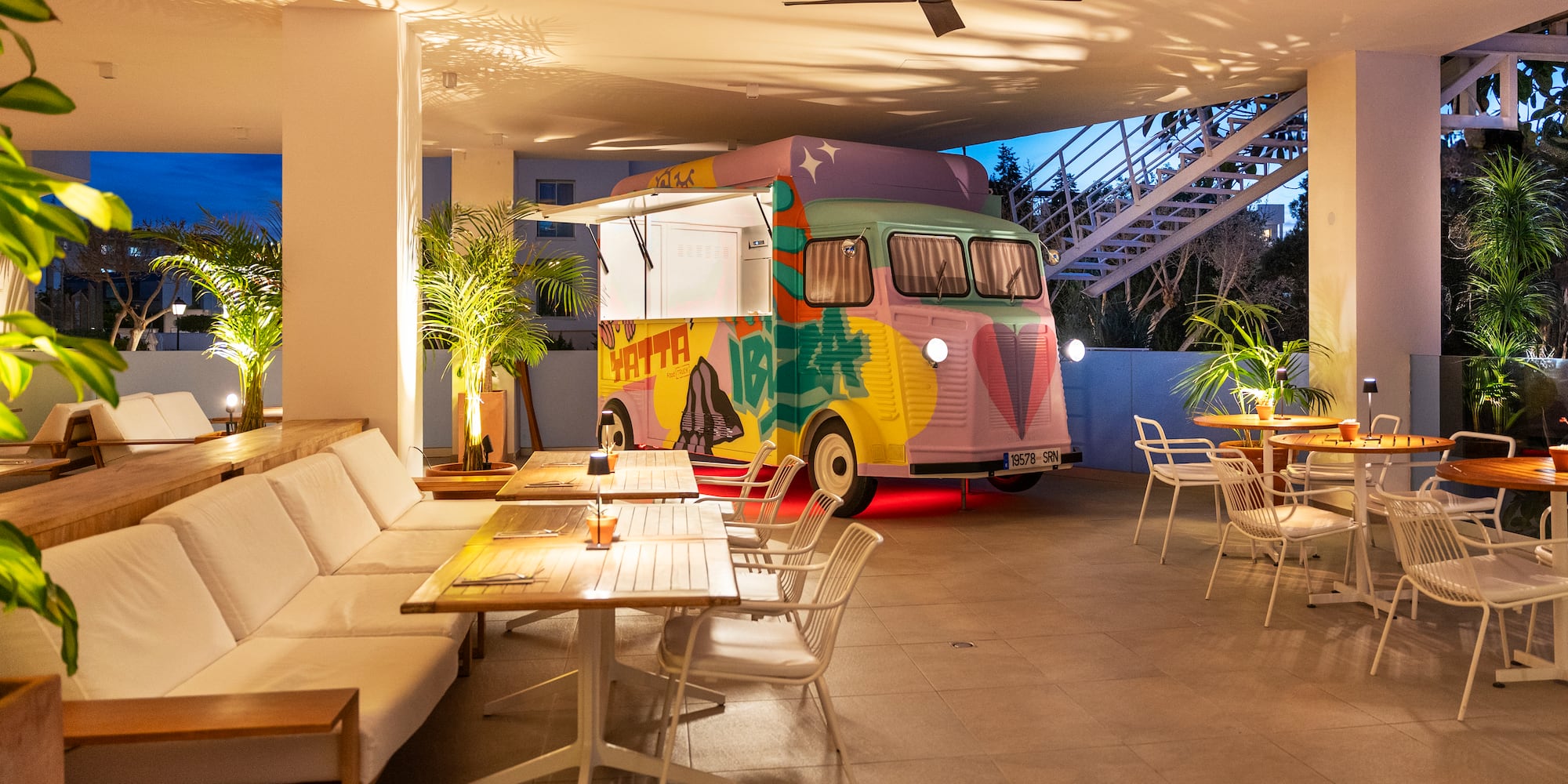 a colorful van parked in a room with tables and chairs
