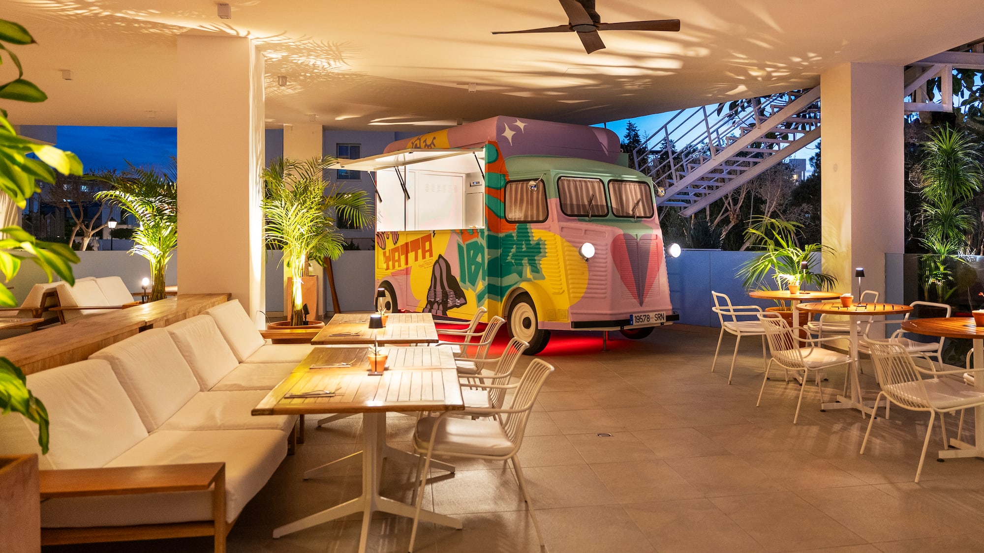 a colorful van parked in a room with tables and chairs